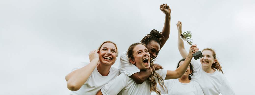 Frauengruppe hält Pokal in den Händen